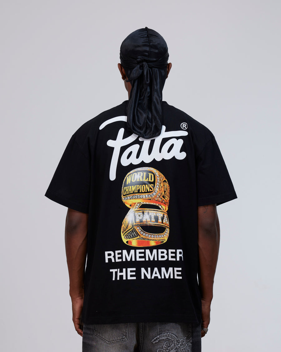 Back view of a model wearing the black cotton Patta Championship T-Shirt with graphic artwork.