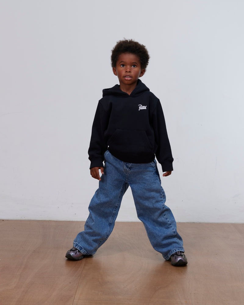 Young boy wearing the black Patta Kids Championship hooded sweater and blue jeans.