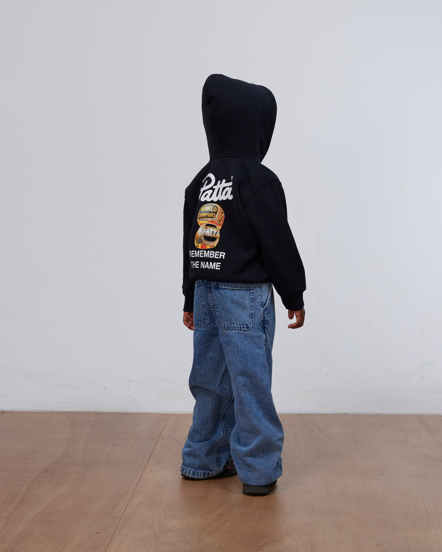 Back view of a kid wearing the black Patta Kids Championship hooded sweater with graphic artwork.